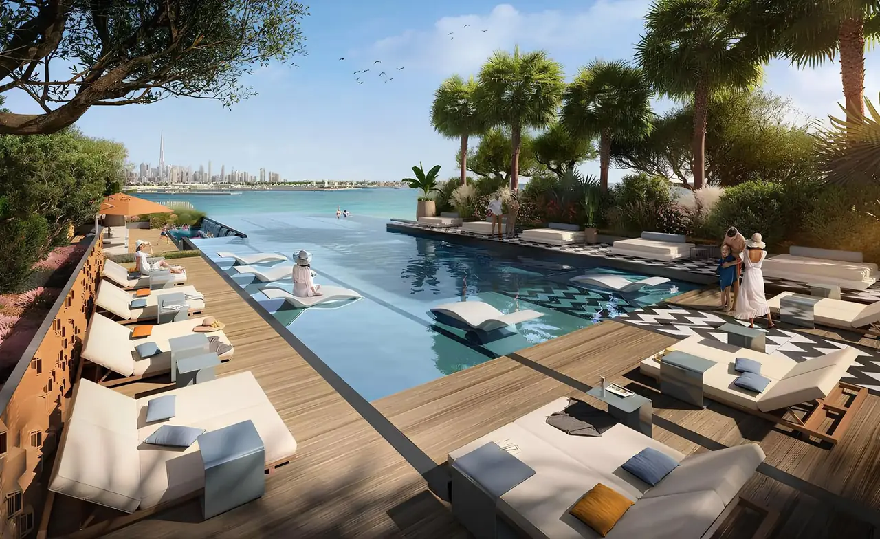 Saria by Beyond in Dubai Maritime City infinity pool deck with timber sun terrace shaded loungers palm garden and open views across the water in Dubai - Presented by Tohid Fetrat