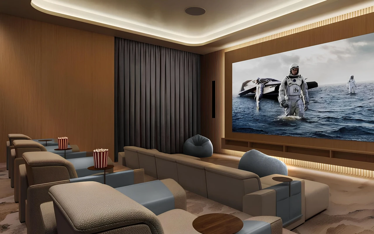 Saria by Beyond in Dubai Maritime City private cinema lounge with tiered recliner seating a wide screen and warm timber wall panelling in Dubai - Presented by Tohid Fetrat