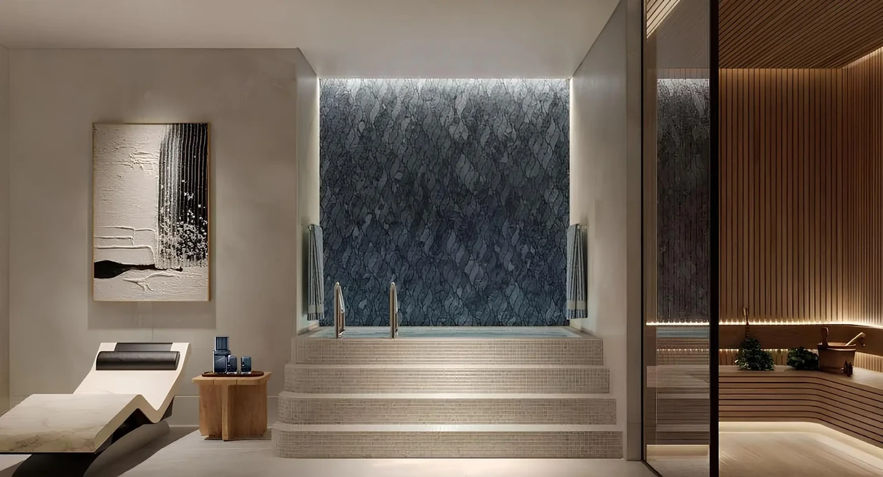 Saria by Beyond in Dubai Maritime City spa suite with a stone water feature wall stepped hydrotherapy pool relaxation lounger and adjoining sauna in Dubai - Presented by Tohid Fetrat