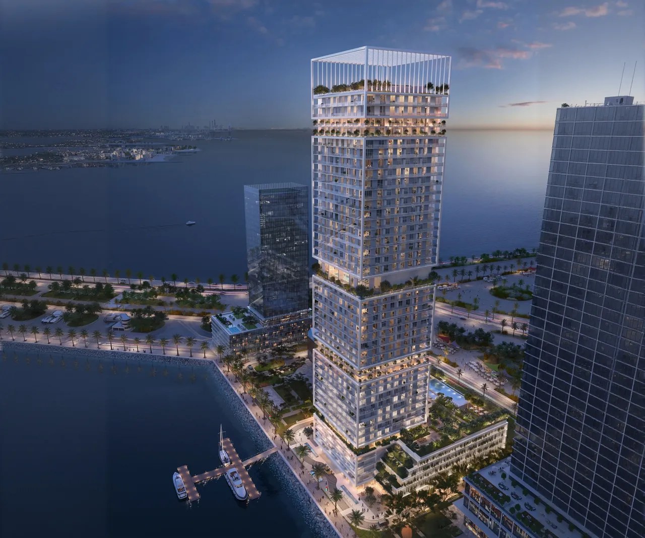 Saria by Beyond in Dubai Maritime City illuminated tower at dusk seen from the water with private moorings promenade planting and neighbouring towers in Dubai - Presented by Tohid Fetrat