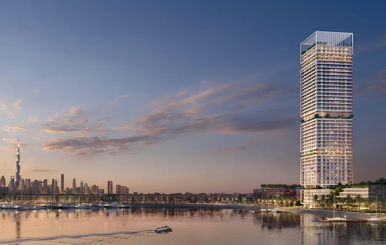 Saria by Beyond in Dubai Maritime City waterfront tower exterior at dusk with illuminated slender facade landscaped podium and marina berths in Dubai Presented by Tohid Fetrat