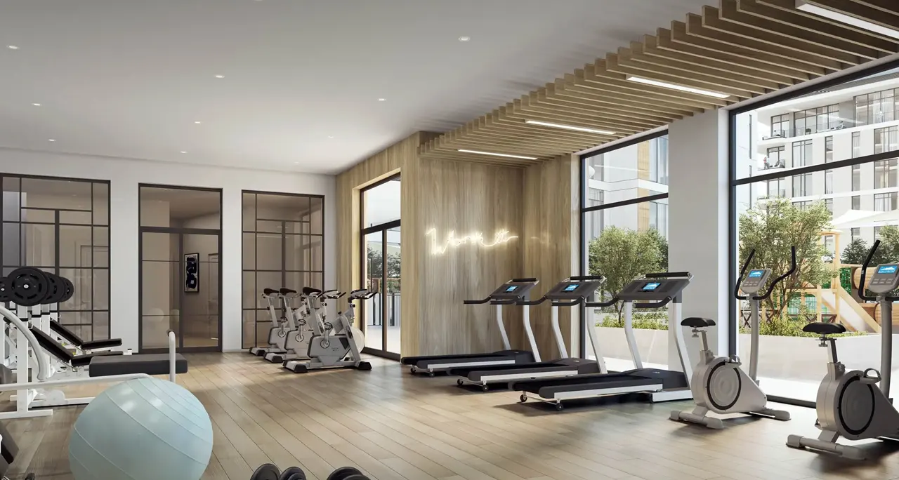 The Cove 2 at Dubai Creek Harbour by Emaar Properties modern fitness center with premium gym equipment and large windows overlooking landscaped outdoor spaces in Dubai Presented by Tohid Fetrat