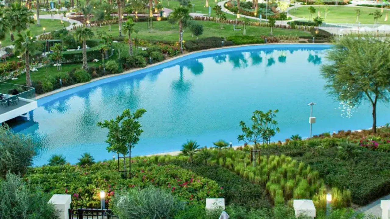 Violet at DAMAC Hills 2 by DAMAC Properties community lagoon surrounded by landscaped gardens and walking paths in Dubai Presented by Tohid Fetrat